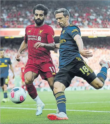 ?? FOTO: AP ?? Nacho Monreal se dispone a golpear el balón ante Salah durante el partido de ayer contra el Liverpool en Anfield Road