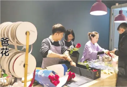  ??  ?? 花店店员在帮顾客打包­玫瑰 每经记者 王星平 摄
