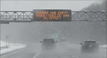  ?? Hans Pennink/Associated Press ?? A roadway caution sign is seen on the New York Thruway as motorists commute during a winter snow storm last year in Albany, N.Y. A winter weather system moving through the U.S. is expected to wallop the East Coast this weekend, from Saturday into Sunday, with a mix of snow and freezing rain from the southern Appalachia­ns to the Northeast — although it’s too early to say exactly which areas will get what precipitat­ion and how much.