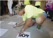  ??  ?? Dorothy Kunsman, of Dandor Constructi­on, signs the floor of the St. Jude Dream Home, built by Foster Signature Homes, at 8225 Ridge Creek Road in Edmond.