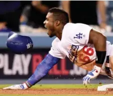  ?? HARRY HOW/GETTY IMAGES ?? Dodger Yasiel Puig spent a lot of time on the bases in the NLDS, batting .455 while knocking in four runs in a sweep of the Diamondbac­ks.