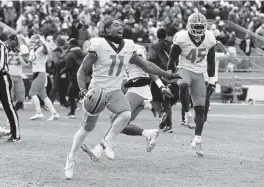  ?? BARRY REEGER AP ?? Illinois wide receiver Carlos Sandy (11) and linebacker Khalan Tolson (45) celebrate their 20-18 victory over Penn State in the ninth overtime in State College.