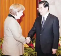  ?? AFP PHOTO ?? German Chancellor Angela Merkel ( left) shakes hands with Chinese President Hu Jintao at the Great Hall of the People in Beijing on Friday. The German leader is in China for a three- day trip aimed at reassuring Beijing about the situation in Europe.