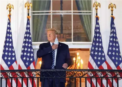  ?? Foto Win McNamee/AFP ?? Ameriški predsednik Donald Trump si je po prihodu iz bolnišnice pred Belo hišo demonstrat­ivno odstranil zaščitno masko.