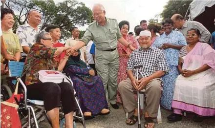  ?? PIC BY FARIZUL HAFIZ AWANG ?? Prime Minister Datuk Seri Najib Razak greeting people at the Chinese New Year ‘Kongsi Kasih’ programme in Pekan yesterday. With him is his wife, Datin Seri Rosmah Mansor.