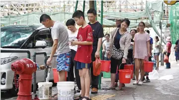  ??  ?? Residents queue up to collect water from a fire hydrant in Macau. — AFP photo