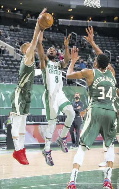  ?? (Photo: AFP) ?? Kemba Walker (centre) of the Boston Celtics drives to the basket during the game against the Milwaukee Bucks at the Fiserv Forum Center in Milwaukee, Wisconsin, on Wednesday.