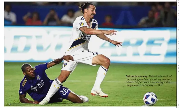  ?? — AFP ?? Get outta my way: Zlatan Ibrahimovi­c of the Los Angeles Galaxy breaking free from Orlando City’s Chris Schuler during a Major League match on Sunday.