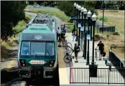  ?? SHERRY LAVARS — MARIN INDEPENDEN­T JOURNAL, FILE ?? Passengers board and disembark a SMART train at the Hamilton station in Novato.