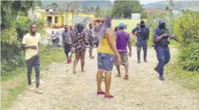  ??  ?? Members of the Jamaica Constabula­ry Force (right) patrol a section of the Allsides community in proximity to where Sunday’s shooting reportedly took place.