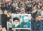  ?? ?? A man with portraits of Supreme Leader Ayatollah Ali Khamenei and Qasem Soleimani.