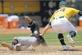  ?? BEN MARGOT/ASSOCIATED PRESS ?? On a wild pitch, Miami’s Dee Gordon scores past A’s pitcher Sonny GrayWednes­day.