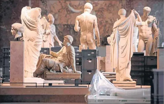  ?? GEOFFROY VAN DER HASSELT / AFP ?? Obras de arte depositada­s en cajas se acumulan entre estatuas de la antigüedad en la primera planta del Museo del Louvre