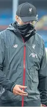  ??  ?? A mask-wearing Jurgen Klopp watched his side move to within five points of their first league title since 1990.