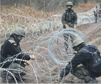  ?? ARTUR RESZKO / EFE ?? Soldados polacos instalaban ayer una alambrada en la frontera con Kaliningra­do.