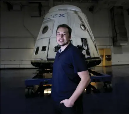  ?? BRIAN VAN DER BRUG, LOS ANGELES TIMES ?? Tesla and SpaceX founder Elon Musk stands in front of the SpaceX Dragon capsule at Space Exploratio­n Technologi­es Corp. SpaceX said Monday that it will fly two private citizens around the moon in its Crew Dragon spacecraft next year.