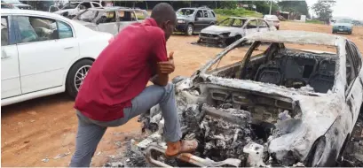  ?? Photo: Felix Onigbinde ?? A motorist yesterday bemoans the burning of his car by suspected hoodlums during a #EndSARS protest at Apo Mechanic in Abuja on Monday night