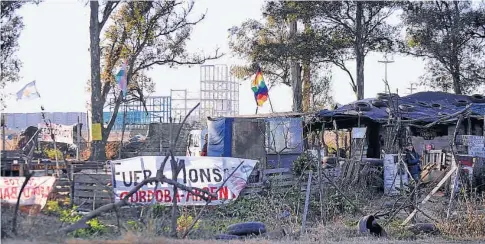  ?? (ANTONIO CARRIZO) ?? Lo que quedó. Carteles y banderas del acampe de Malvinas, delante de las obras nunca completada­s de Monsanto.