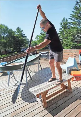  ?? MICHAEL SEARS/USA TODAY NETWORK ?? Cris Rosario uses a bench to teach customers the correct way to navigate paddle boards.