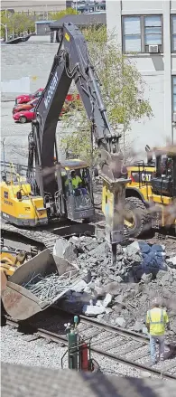  ?? STAFF PHOTOS BY STUART CAHILL ?? WEEKEND SHIFT: Early phase work on the Green Line Extension project, above and below, begins near railroad tracks in Somerville yesterday.