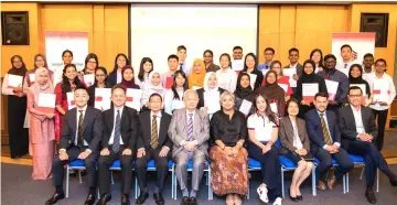  ??  ?? Quek (seated, fourth right) together with directors from Hong Leong Foundation and other companies posing for a photo with recipients of the Hong Leong Foundation scholarshi­p.