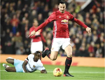  ??  ?? Manchester United’s Swedish striker Zlatan Ibrahimovi­c scores his team’s first goal during the EFL (English Football League) Cup quarterfin­al football match between Manchester United and West Ham United at Old Trafford in Manchester, north west...