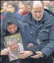  ?? AP ?? Relatives of a Ukrainian plane crash victim at a memorial service outside of Kyiv.