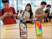  ?? WANG GANG / FOR CHINA DAILY ?? Customers select new iPhone products at the Apple flagship store in East Nanjing Road, Shanghai, on Sept 21.
