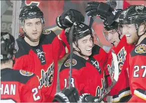  ?? TED RHODES ?? Dougie Hamilton, right, celebrates his second period goal with, from right, his brother Freddie, Johnny Gaudreau, TJ Brodie and Sean Monahan against the Blackhawks at the Saddledome on Saturday.