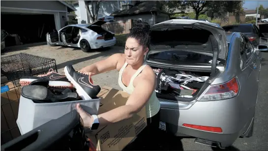  ?? KENT PORTER — THE PRESS DEMOCRAT VIA AP ?? Chrissy Pierce, of Windsor, puts her family’s belongings into the car as she prepares to evacuate from the threat of the Kincade Fire on Saturday.