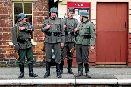  ?? PHOTOS: GETTY IMAGES ?? Military re-enactors dressed as World War II German soldiers stand on the railway station platform at Levisham, renamed Le Visham, during last year’s North Yorkshire Moors Railway ‘‘Railway In Wartime’’ weekend. The re-enactors have not been invited to this year’s event after they attracted negative publicity.