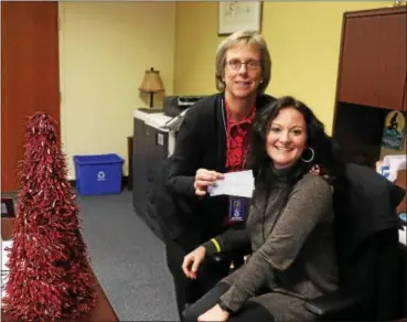  ?? SUBMITTED PHOTO ?? Downingtow­n Area School District Business Office employees Laurie Peiffer, left, and Cynthia Newlin, right, hold checks of the latest donors to play Secret Santa in the district by anonymousl­y helping families to pay off the negative meal balances at...