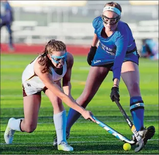  ?? SARAH GORDON/THE DAY ?? Stonington’s Miranda Arruda, left, hits a ball past Val Neuhausser of Lewis Mills during a Class S state tournament field hockey quarterfin­al Thursday. Arruda finished with four goals in the 8-0 victory.