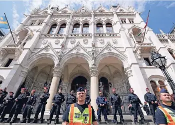  ?? FOTO: GETTY ?? Drinnen konstituie­rt sich das neu gewählte ungarische Parlament nach der Wahl am 8. April, draußen schützen Polizisten das Gebäude in Budapest vor Demonstran­ten.