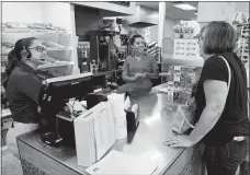  ?? SEAN D. ELLIOT/ THE DAY ?? Assistant Manager Cassie Bingham, left, and Manager Kayla Thomas greet customers Nanci and Gary Russell at the new Baker’s Dozen in Gales Ferry.