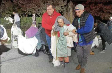  ?? PETE BANNAN – DIGITAL FIRST MEDIA ?? A resident of the Barclay Friends Home is assisted away from the scene as the senior care facility burned in a horrific fire late Thursday evening. Hundreds of residents were evacuated from after fire destroyed the home.