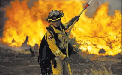  ?? Marcio Jose Sanchez ?? The Associated Press A firefighte­r makes a stand in front of a wildfire as it approaches a residence Saturday near Redding, Calif. The Carr Fire was threatenin­g thousands of homes and is not expected to be fully contained until at least mid-august.