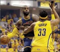  ?? AP/ MICHAEL CONROY ?? Cleveland forward LeBron James ( left) wraps a pass around Indiana defender Myles Turner in the fi rst half of Thursday night’s NBA Eastern Conference playoff game. James scored 28 of his 41 points in the second half to rally the Cavaliers back from a...