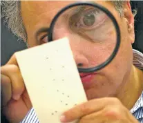  ?? ASSOCIATED PRESS FILE PHOTO ?? Canvassing board member Judge Robert Rosenberg examines a disputed ballot at the Broward County Courthouse in Fort Lauderdale, Fla., November, 2000. Florida’s punch cards became a symbol of a disputed presidenti­al election. This year, it could be poorly marked ovals or boxes.