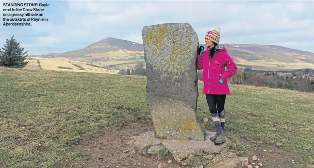  ??  ?? STANDING STONE: Gayle next to the Craw Stane on a grassy hillside on the outskirts of Rhynie in Aberdeensh­ire.