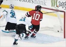  ?? NOAH K. MURRAY
THE ASSOCIATED PRESS ?? New Jersey centre Jean-Sebastien Dea scores against San Jose Sharks goaltender Martin Jones and defenceman Justin Braun on Sunday.