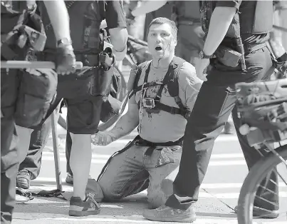  ?? AP Photo/Ted S. Warren ?? ■ A man who was protesting with Patriot Prayer and other groups supporting gun rights is treated for an injury during a rally and counter-protest Saturday near City Hall in Seattle.