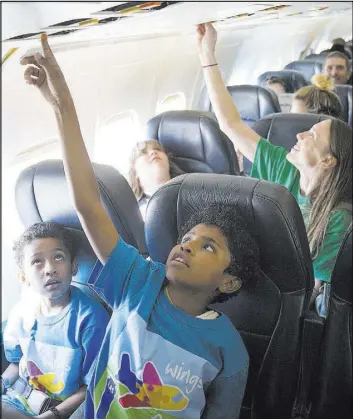  ?? Erik Verduzco Las Vegas Review-Journal @Erik_Verduzco ?? Romeo Knox, 9, left, and brother Roman, 11, inside an Allegiant plane during the Wings for Autism event Saturday at McCarran Internatio­nal Airport.