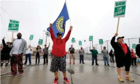  ??  ?? United Auto Workers (UAW) members picket at a gate at the General Motors Flint assembly plant on Monday. Photograph: Bill Pugliano/Getty Images