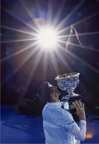  ?? Asanka Brendon Ratnayake / Associated Press ?? Novak Djokovic holds the Norman Brookes Challenge Cup after defeating Stefanos Tsitsipas in the men’s singles final at the Australian Open on Sunday.