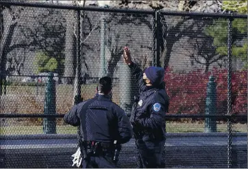  ?? JOHN MINCHILLO — THE ASSOCIATED PRESS ?? Capitol Police officers look at fencing that was installed around the exterior of the Capitol grounds on Thursday.