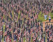  ?? MATT YORK / AP ?? A couple walk through the “healing field” at Tempe Beach Park in Tempe, Ariz., on Sept. 11, 2013.