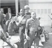  ?? AP 1963 ?? Revs. Ralph Abernathy, left, and Martin Luther King Jr. are taken by a policeman as they lead demonstrat­ors in a march to end racial segregatio­n in Birmingham, Alabama.