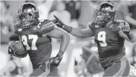  ?? MICHAEL LAUGHLIN/SUN SENTINEL ?? Miami’s Jonathan Garvin gets an escort from defensive lineman Gerald Willis III and scores a touchdown after a North Carolina fumble in the first half of the Hurricanes’ ACC opener.