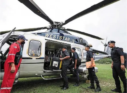  ?? — bernama ?? Reaching far and wide: Workers carrying bags containing ballot papers onto a helicopter to be sent to polling stations in Pulau redang in terengganu.